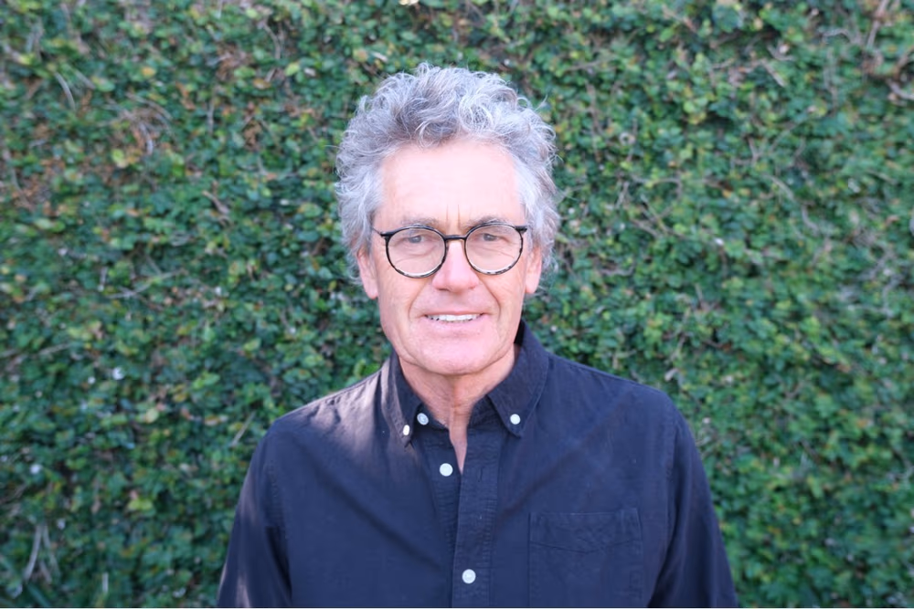 2024 Writers’ Award winner Mark Derby standing in front of an ivy hedge.